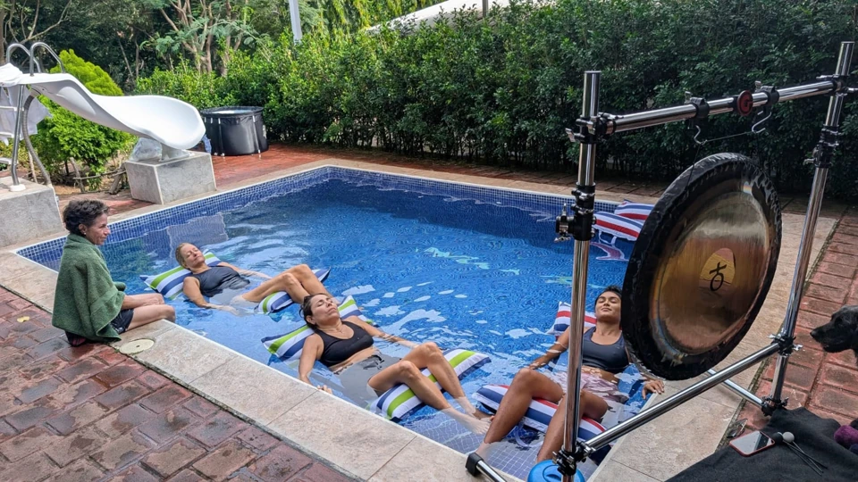 group of people having a gong bath in a pool